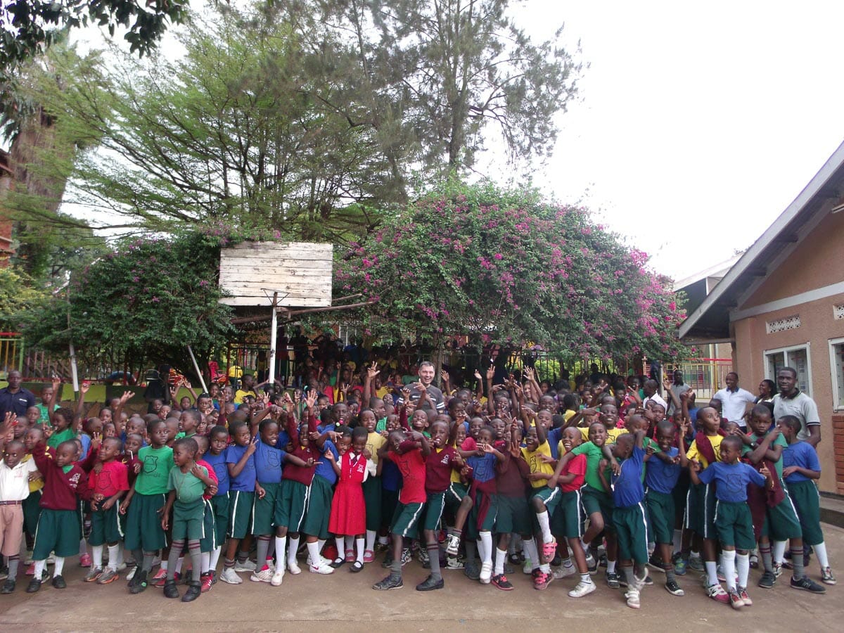 Hundreds of students waving at a JAAS Foundation partner school in Uganda